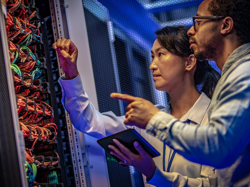 Two data center technical and project management services experts servicing a data center server